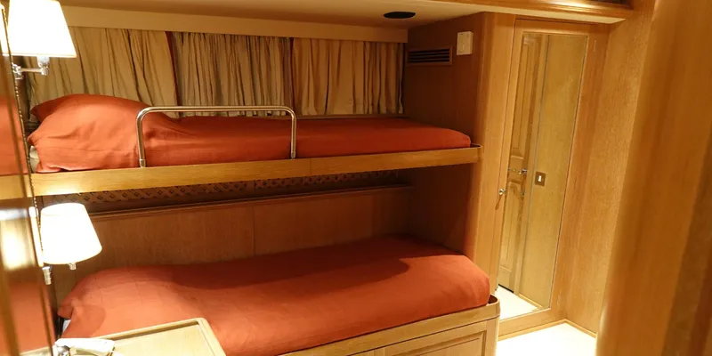 Althea Yacht Photos Pics Bunk beds in a 1993 Aegean Yacht Schooner cabin with red bedding and wooden interior.
