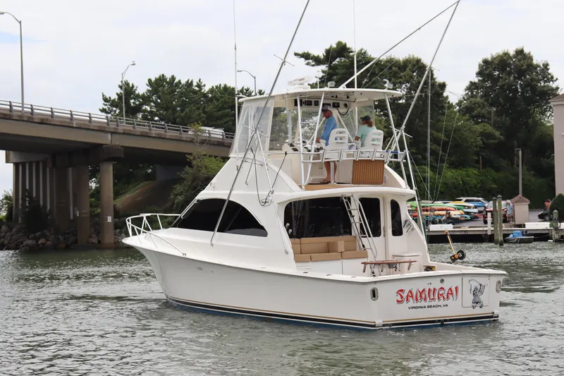  Yacht Photos Pics 2004 Ocean Yachts 43 Super Sport boat cruising near a bridge and marina.