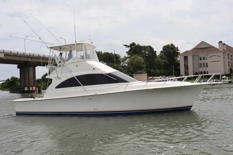  Yacht Photos Pics 2004 Ocean Yachts 43 Super Sport cruising near a bridge and waterfront buildings.