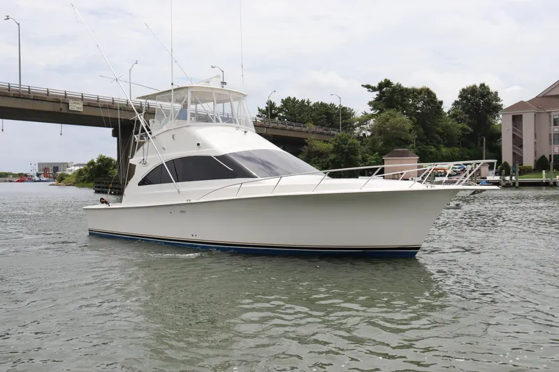  Yacht Photos Pics 2004 Ocean Yachts 43 Super Sport cruising on a calm waterway near a bridge.