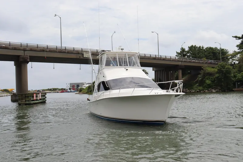  Yacht Photos Pics 2004 Ocean Yachts 43 Super Sport cruising under a bridge on a calm waterway.