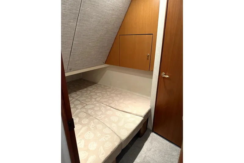  Yacht Photos Pics 2004 Ocean Yachts 43 Super Sport cabin with cozy bed and wooden storage.