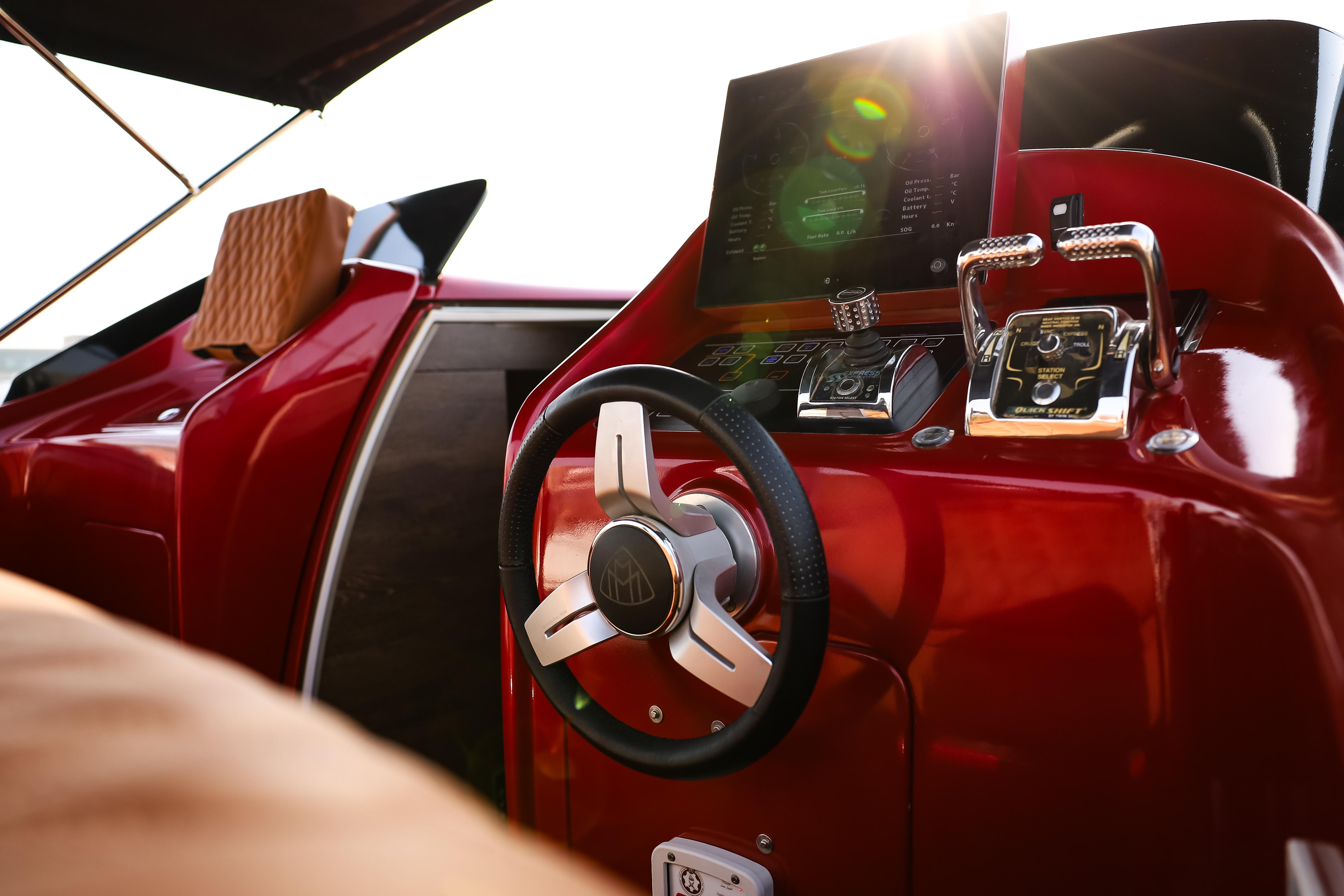 2016 Silver Arrow 460 GT yacht interior with sleek red dashboard and modern steering wheel.