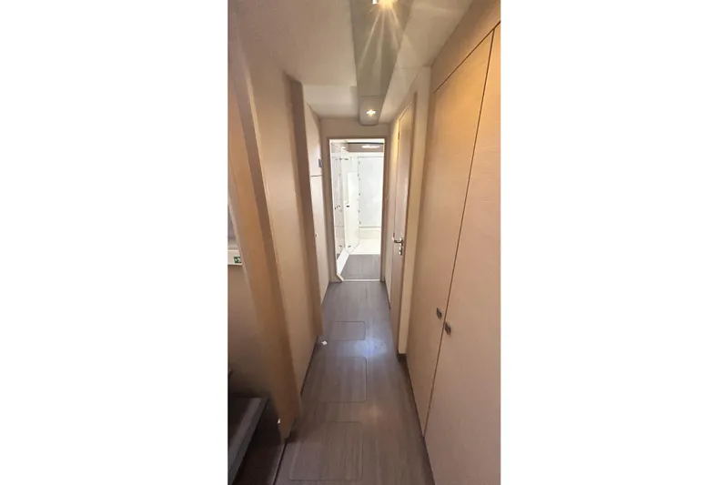  Yacht Photos Pics Narrow hallway inside 2019 Fountaine Pajot Helia 44 Evolution catamaran, featuring modern wood paneling.