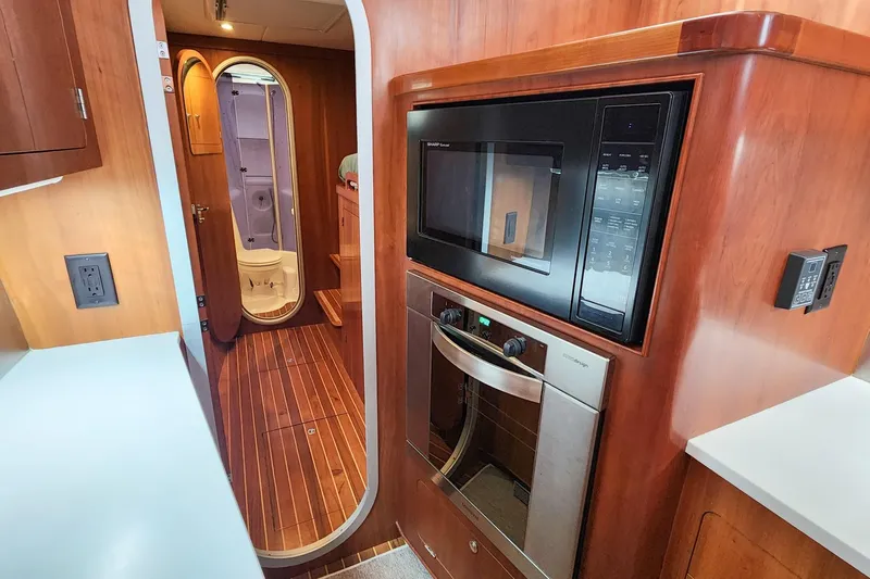 Cinnamon Yacht Photos Pics Interior of 2019 Antares 44GT yacht featuring modern kitchen appliances and wooden flooring.