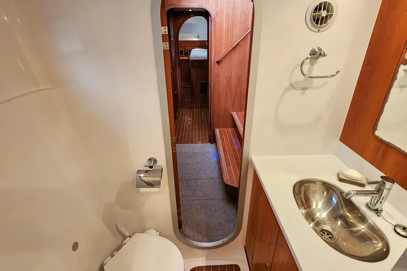 Cinnamon Yacht Photos Pics Antares 44GT 2019 yacht bathroom with sink, toilet, and wooden interior.