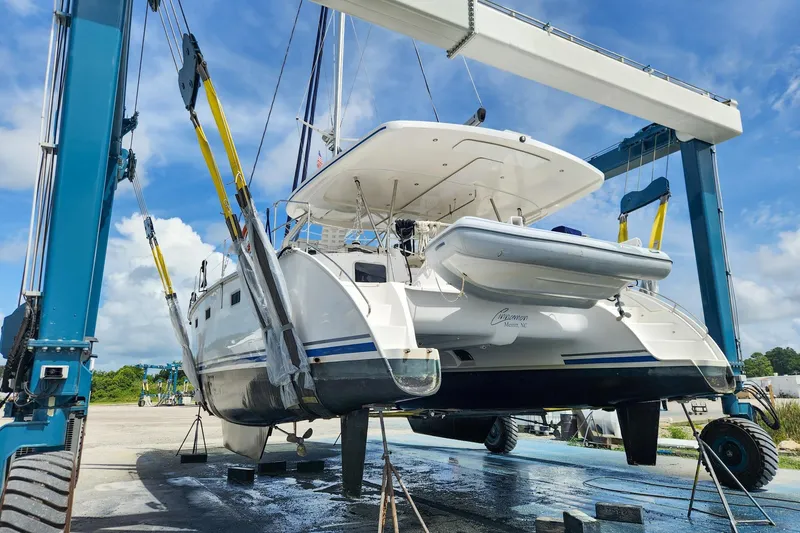 Cinnamon Yacht Photos Pics 2019 Antares 44GT catamaran lifted by crane in a boatyard under blue sky.