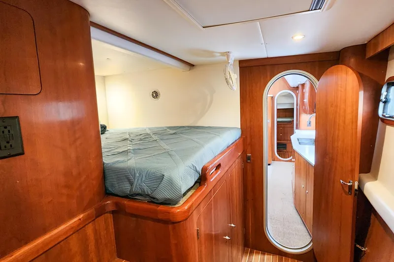 Cinnamon Yacht Photos Pics Cozy cabin interior of 2019 Antares 44GT yacht with wooden finish and bed.