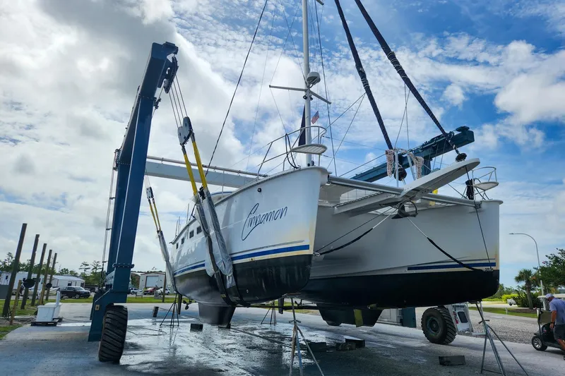 Cinnamon Yacht Photos Pics 2019 Antares 44GT catamaran lifted by crane under a cloudy sky.
