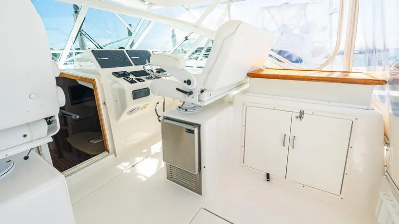  Yacht Photos Pics 2008 Cabo 38 Express yacht helm with white seating and control panel.