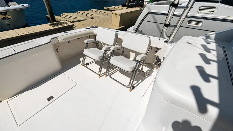  Yacht Photos Pics 2008 Cabo 38 Express boat deck with two white chairs, docked by the water.