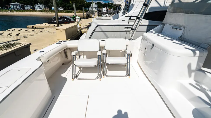  Yacht Photos Pics 2008 Cabo 38 Express boat deck with chairs, docked by the water.