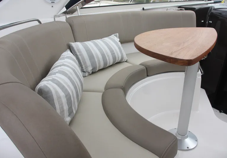 Sapphire Yacht Photos Pics Luxurious seating area on a 2014 Regal 38 Express yacht with striped cushions and wooden table.