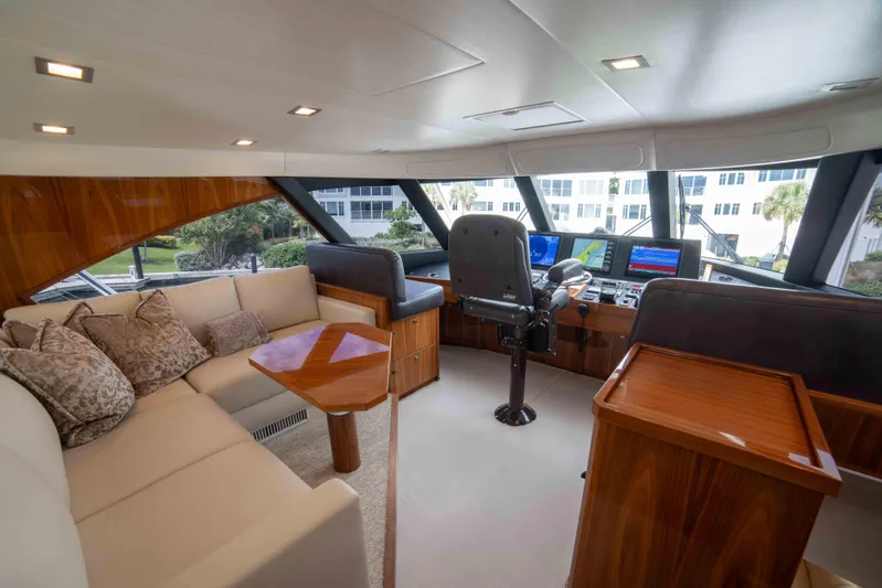 Reely Dude Yacht Photos Pics Luxurious interior of 2019 Viking 72 Enclosed Bridge yacht with plush seating and navigation controls.