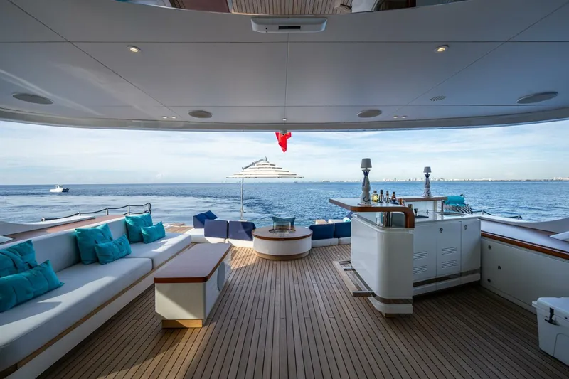 King's Lair Yacht Photos Pics Luxurious 2023 Benetti 34M OASIS yacht deck with seating, bar, and ocean view.