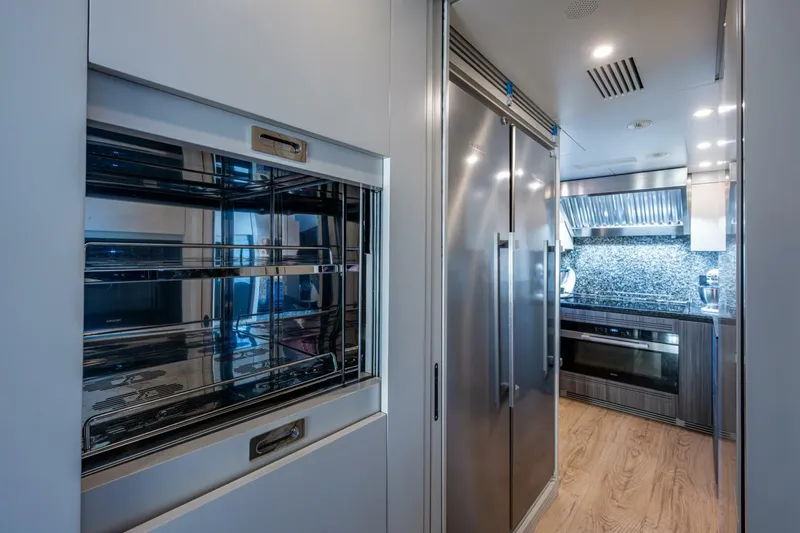 King's Lair Yacht Photos Pics Modern kitchen interior on 2023 Benetti 34M OASIS yacht, featuring stainless steel appliances.