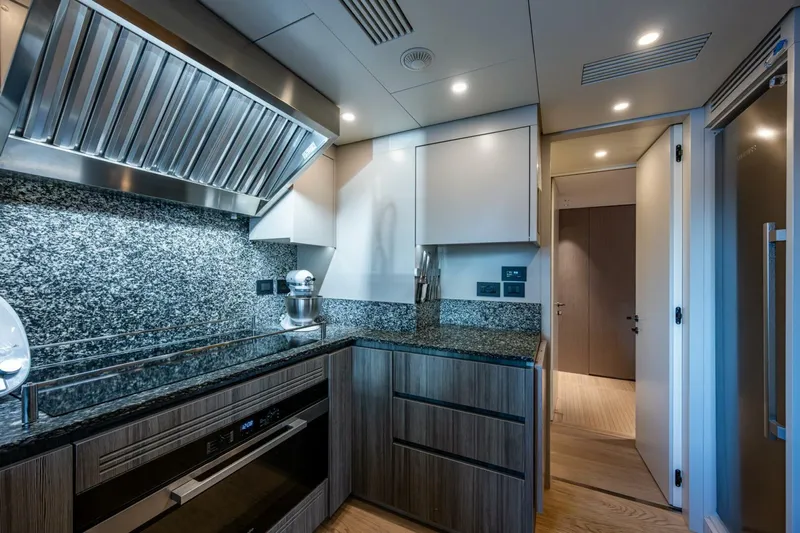 King's Lair Yacht Photos Pics Modern kitchen interior on 2023 Benetti 34M OASIS yacht, featuring sleek design and granite countertops.