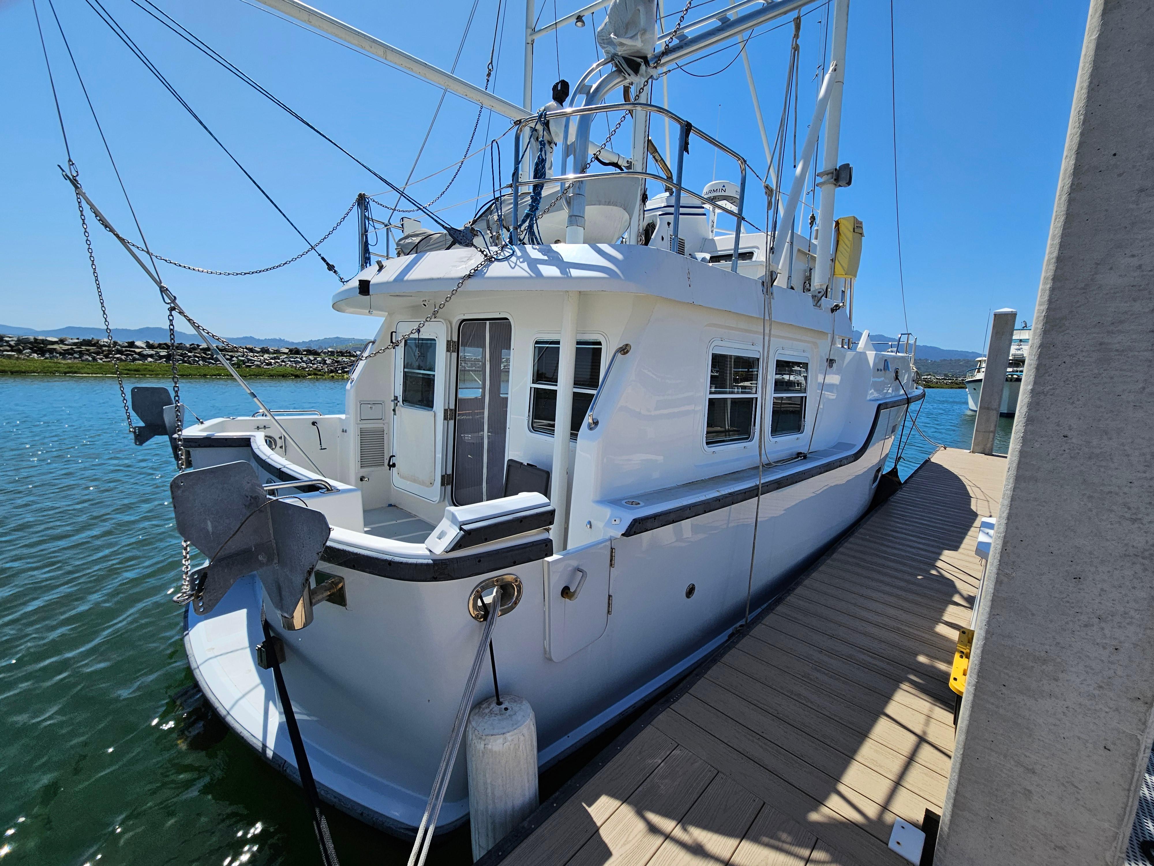 2002 Nordhavn Trawler docked, showcasing its sturdy design and spacious deck.