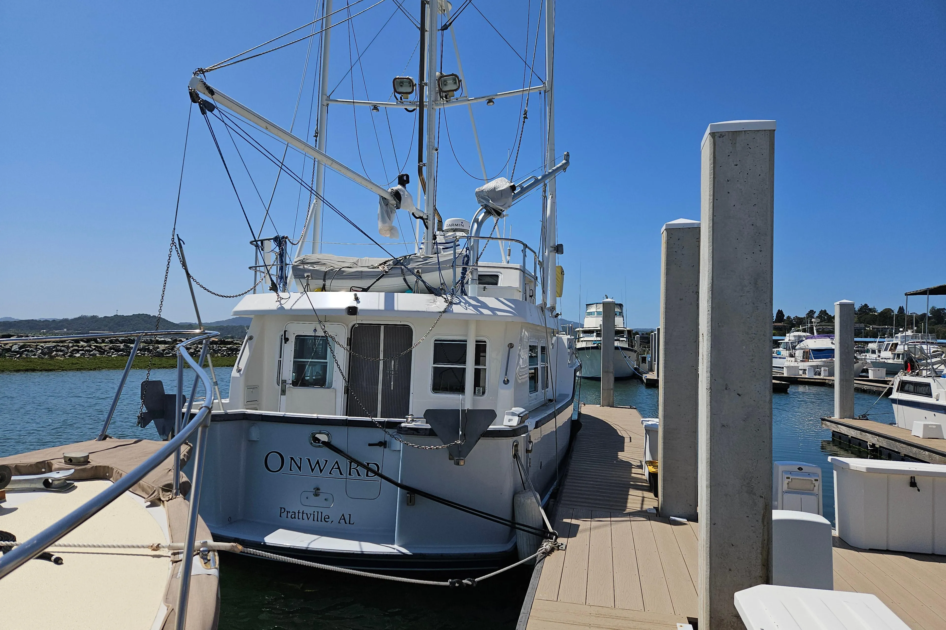 2002 Nordhavn Trawler docked at marina under clear blue sky.