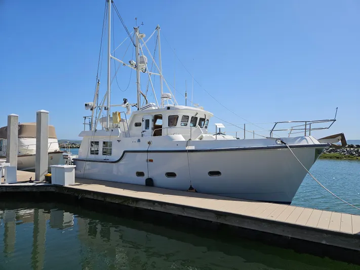 Good Job Yacht Photos Pics 2002 Nordhavn Trawler docked at marina under clear blue sky.
