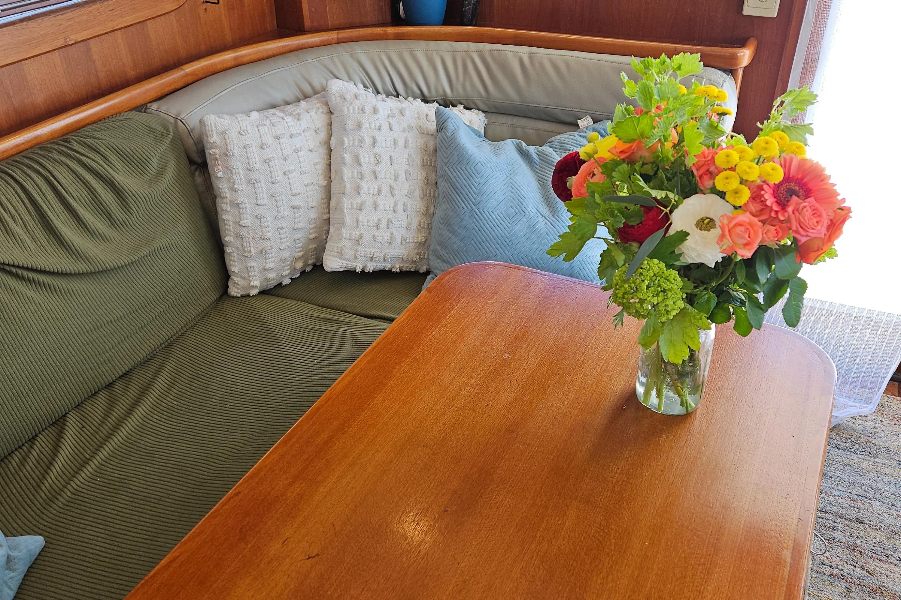 Cozy Nordhavn 2002 trawler interior with floral arrangement on wooden table.