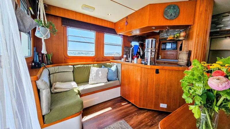 Good Job Yacht Photos Pics Cozy 2002 Nordhavn Trawler interior with wooden decor, seating area, and vibrant flowers.