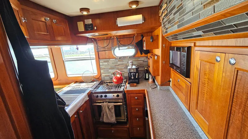 Good Job Yacht Photos Pics 2002 Nordhavn Trawler kitchen with wooden cabinets, stove, and modern appliances.
