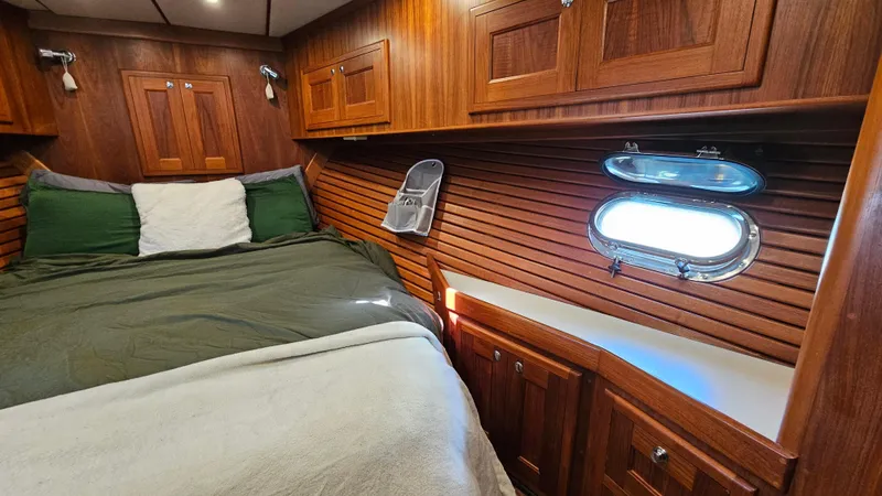 Good Job Yacht Photos Pics Cozy 2002 Nordhavn Trawler cabin with wood paneling, bed, and porthole window.