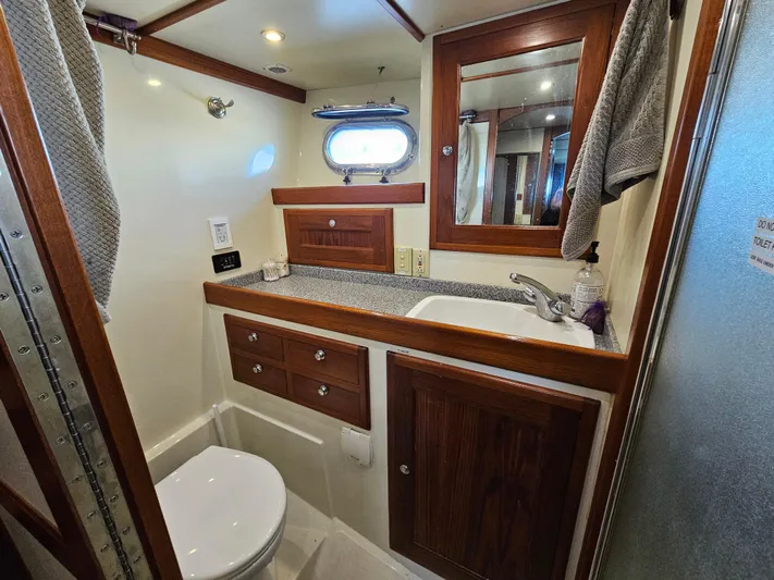 Good Job Yacht Photos Pics Bathroom interior of 2002 Nordhavn Trawler with wood accents and porthole window.