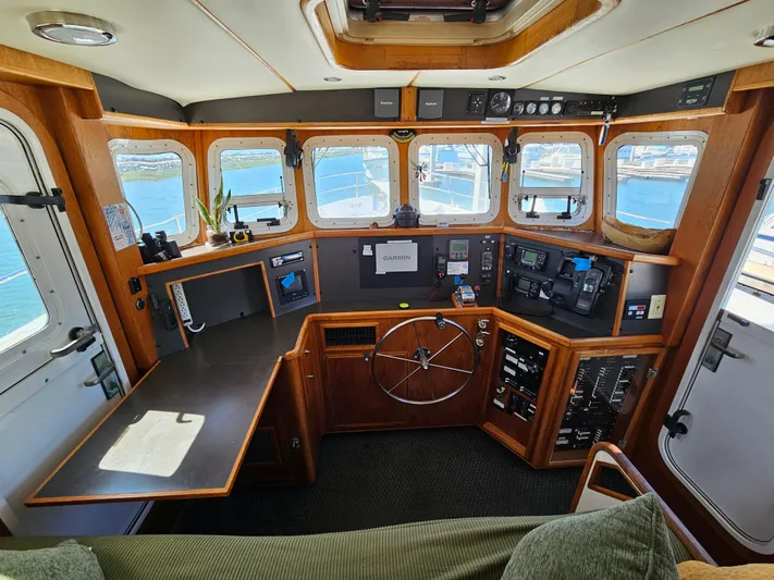 Good Job Yacht Photos Pics Pilothouse of a 2002 Nordhavn Trawler with navigation equipment and panoramic windows.