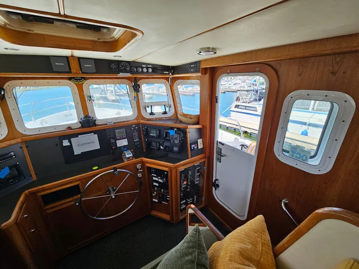 Good Job Yacht Photos Pics Pilothouse of 2002 Nordhavn Trawler with wooden interior and navigational equipment.