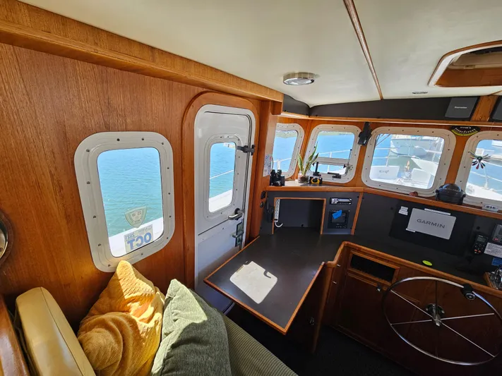 Good Job Yacht Photos Pics Interior of a 2002 Nordhavn Trawler with wooden paneling and navigation equipment.
