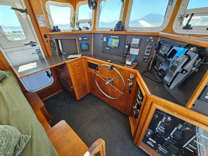 Good Job Yacht Photos Pics Pilothouse of a 2002 Nordhavn Trawler with navigation equipment and wooden interior.