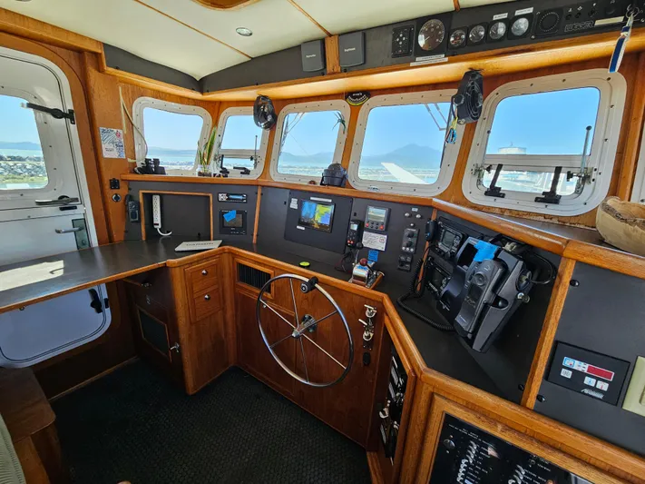 Good Job Yacht Photos Pics 2002 Nordhavn Trawler helm with wooden interior and navigation equipment.