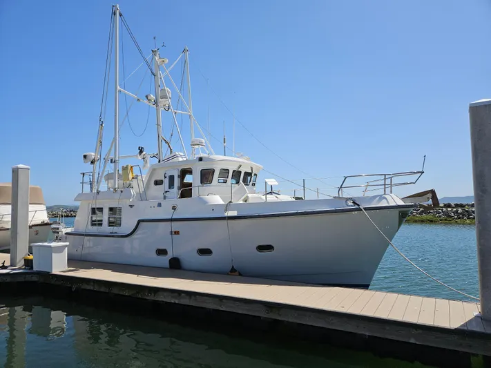 Good Job Yacht Photos Pics 2002 Nordhavn Trawler docked at marina under clear blue sky.