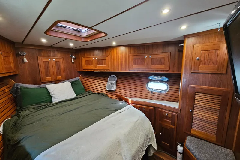 Good Job Yacht Photos Pics Luxurious 2002 Nordhavn Trawler cabin with wood paneling and cozy bedding.