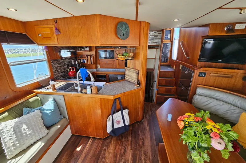Good Job Yacht Photos Pics Interior of a 2002 Nordhavn Trawler with cozy seating, kitchen, and dining area.
