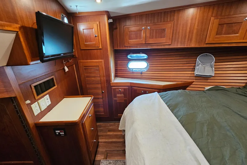 Good Job Yacht Photos Pics Luxurious 2002 Nordhavn Trawler cabin with wood paneling, bed, and TV.