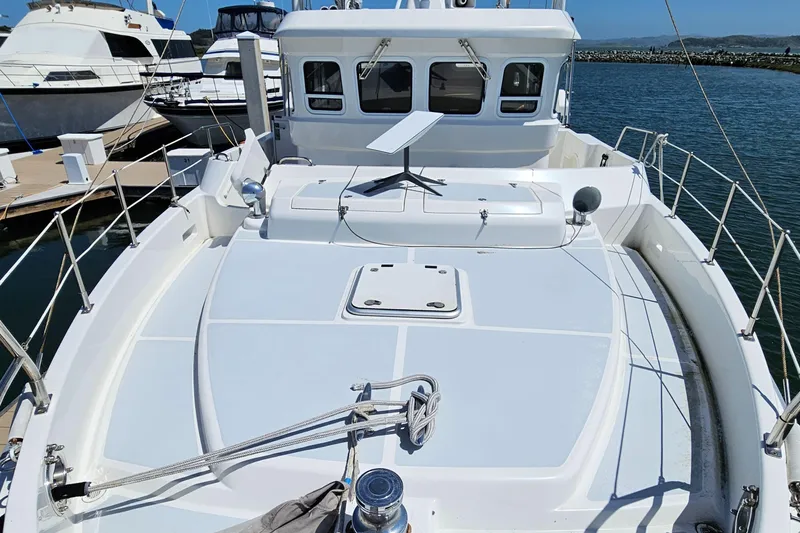 Good Job Yacht Photos Pics 2002 Nordhavn Trawler boat deck with railing, docked in marina under clear sky.