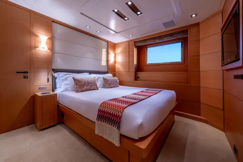 Lady H Yacht Photos Pics Luxurious bedroom interior on 2011 Benetti Majesty 120 yacht, featuring elegant wood paneling.
