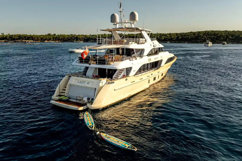 Lady H Yacht Photos Pics Luxurious 2011 Benetti Majesty 120 yacht on serene waters, with paddleboards attached.