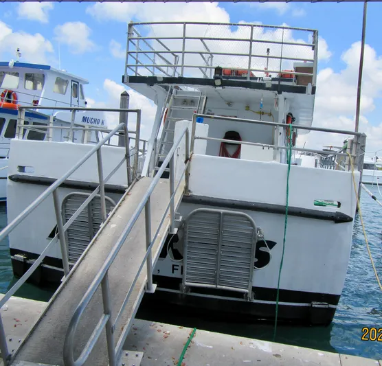 Atlantis Yacht Photos Pics Commercial drift fishing boat docked, 1986 model, with boarding ramp and upper deck.