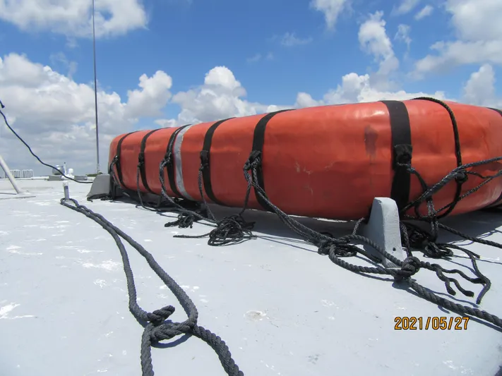Atlantis Yacht Photos Pics Orange life raft on 1986 Drift Fishing Party boat deck, secured with black straps.