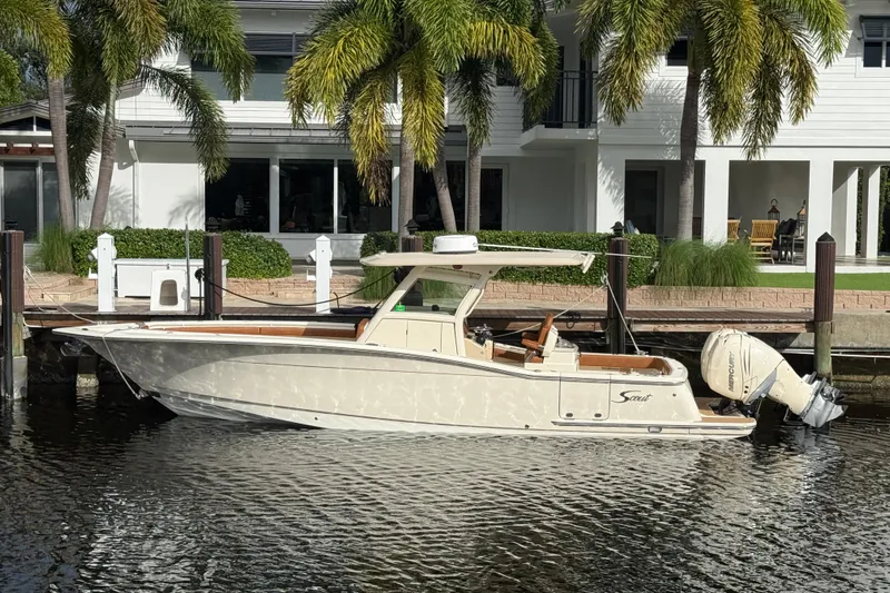 T/t B Happy Yacht Photos Pics 2019 Scout 320 LXF boat docked by waterfront home with palm trees.
