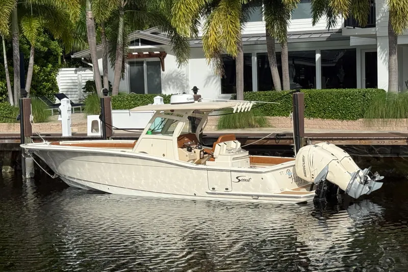T/t B Happy Yacht Photos Pics 2019 Scout 320 LXF boat docked by a waterfront home with palm trees.