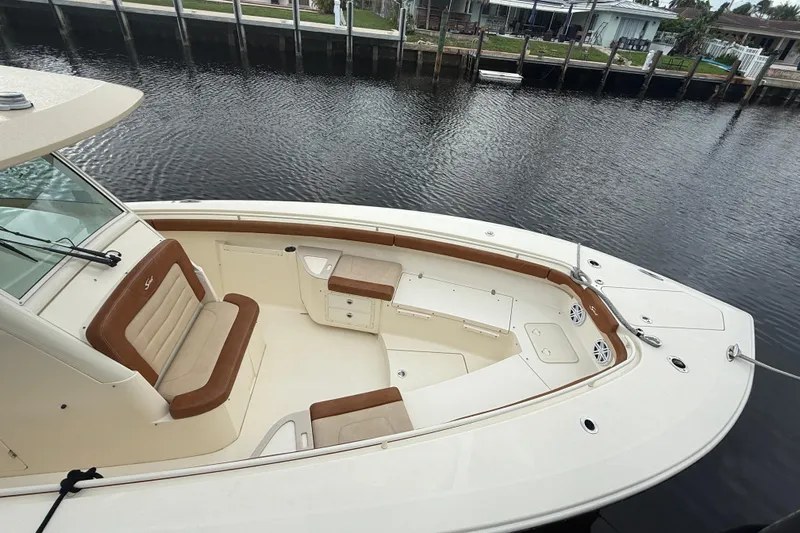 T/t B Happy Yacht Photos Pics 2019 Scout 320 LXF boat with spacious seating, docked by a calm waterfront.