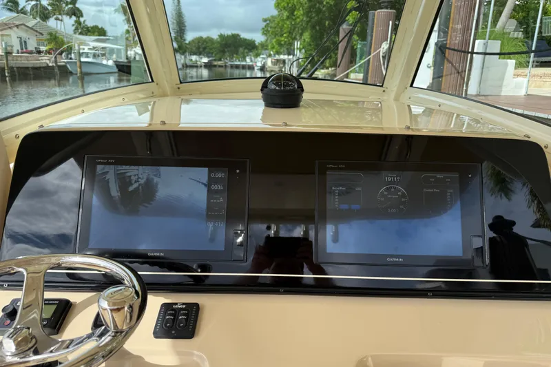 T/t B Happy Yacht Photos Pics 2019 Scout 320 LXF boat dashboard with dual Garmin displays and steering wheel.