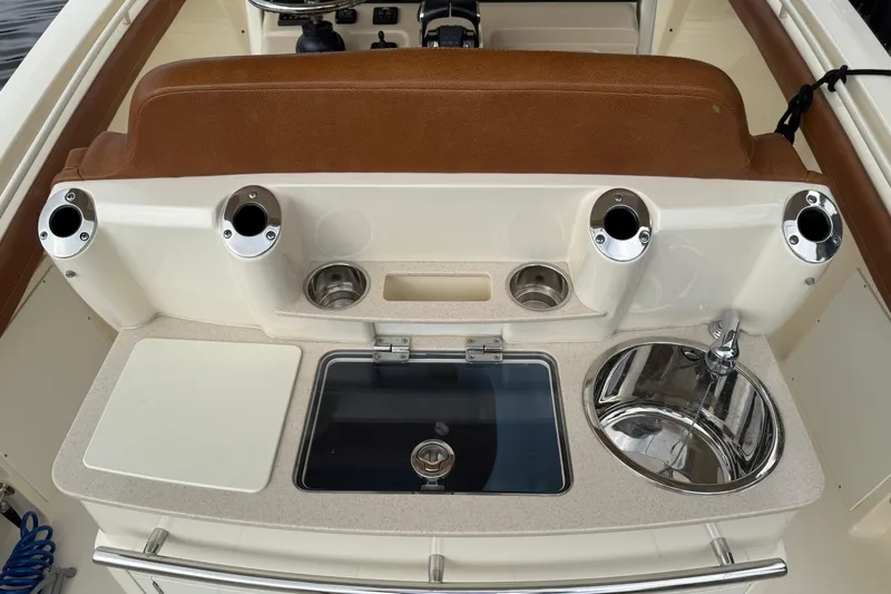 T/t B Happy Yacht Photos Pics 2019 Scout 320 LXF boat interior with sink, rod holders, and cutting board.