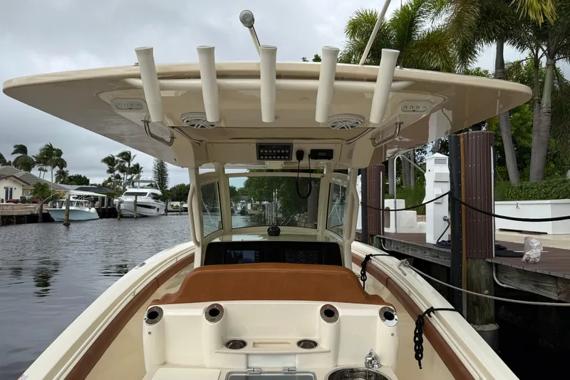 T/t B Happy Yacht Photos Pics 2019 Scout 320 LXF boat docked by a canal with palm trees.