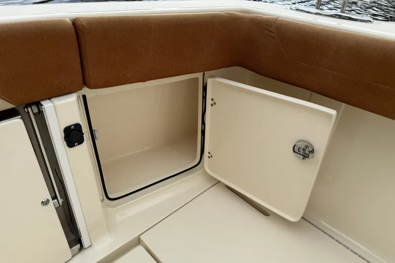 T/t B Happy Yacht Photos Pics 2019 Scout 320 LXF boat storage compartment with brown cushioned seating.